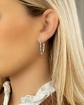 Mooie tennis oorbellen met kettinkje in het oor van het model in het zilver