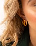 Model draagt Chunky oval hoop earrings goldplated in oor