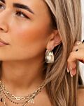 Model draagt zilveren gestreepte hoops
