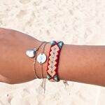 Zilveren initial armband met gekleurde armbandjes om de pols