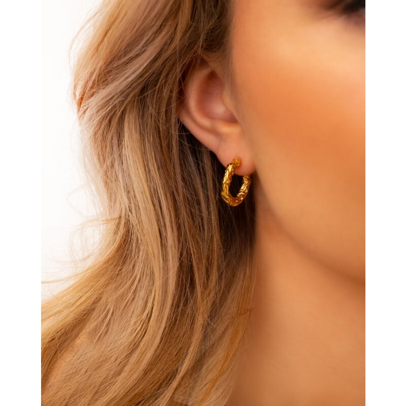 Model draagt Hammered hoops goudkleurig in oor