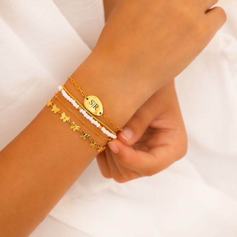 Model draagt mix van gouden armbanden