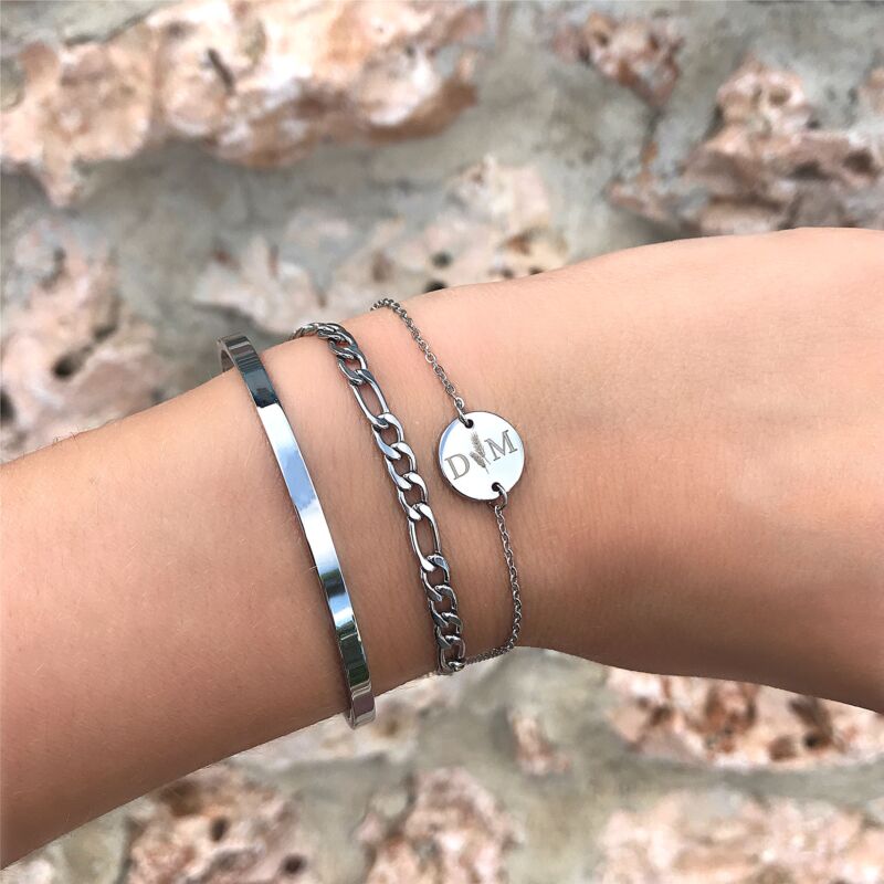 Zilverkleurige armbandjes om de pols met gravering en minimalistische bangle