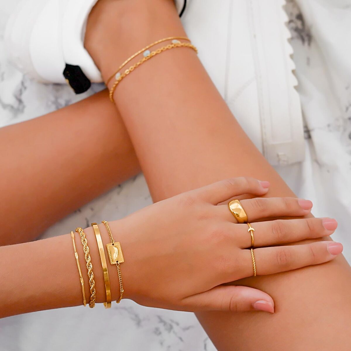 Trendy mix van sieraden om de pols en hand