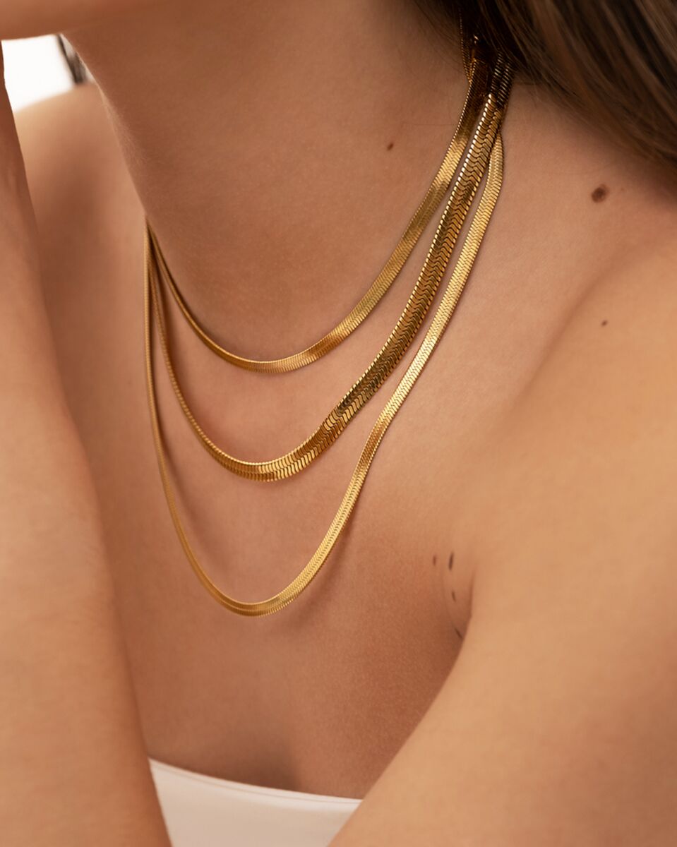 Model draagt gouden kettingen mix