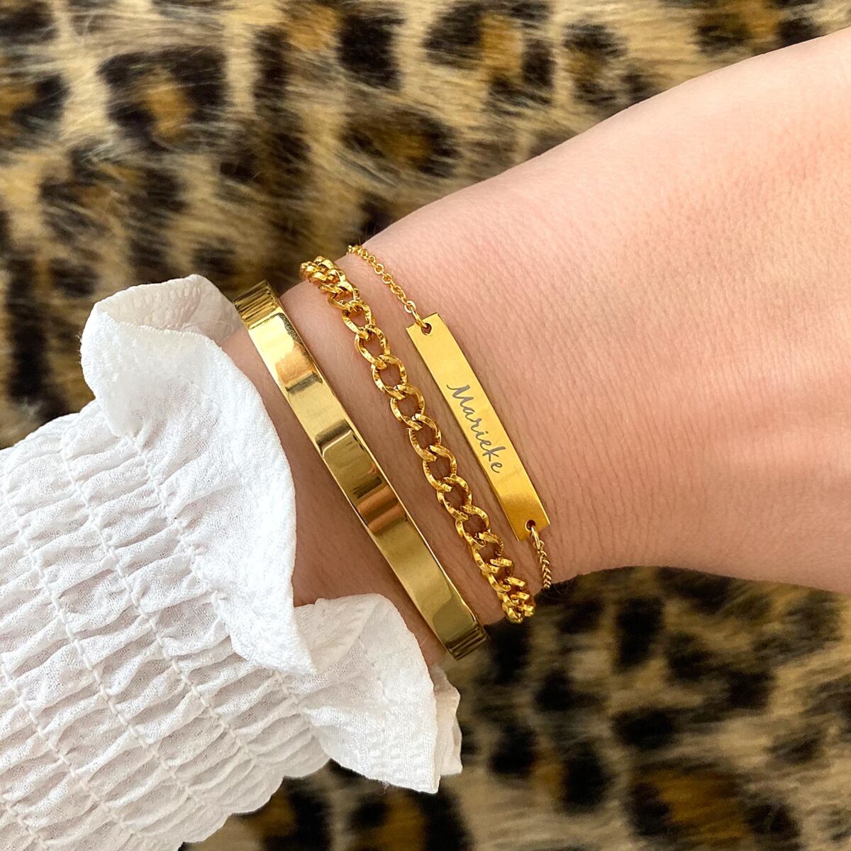 Vrouw draagt gouden armparty om de pols met nieuwe gravering