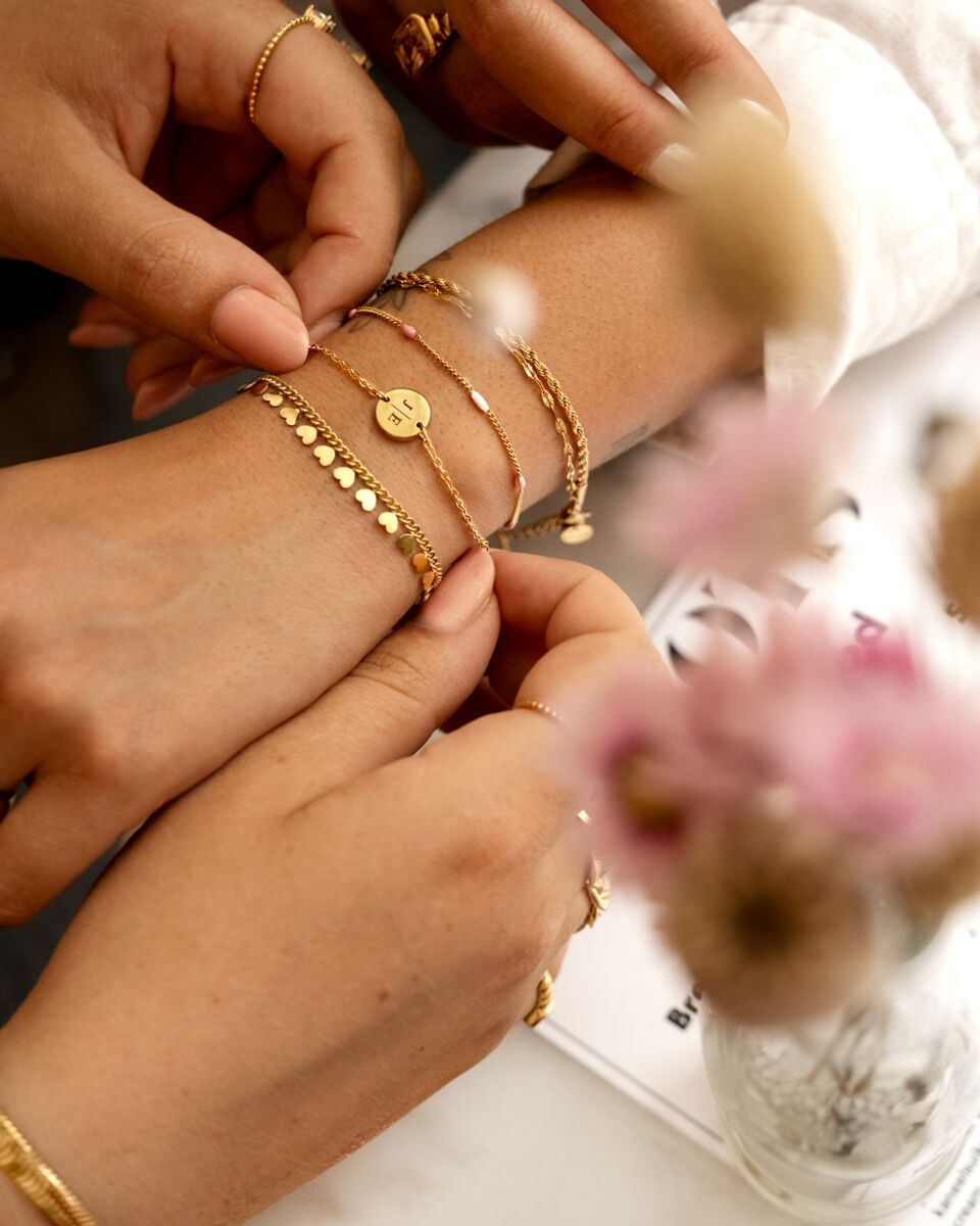 Model draagt gouden armbanden