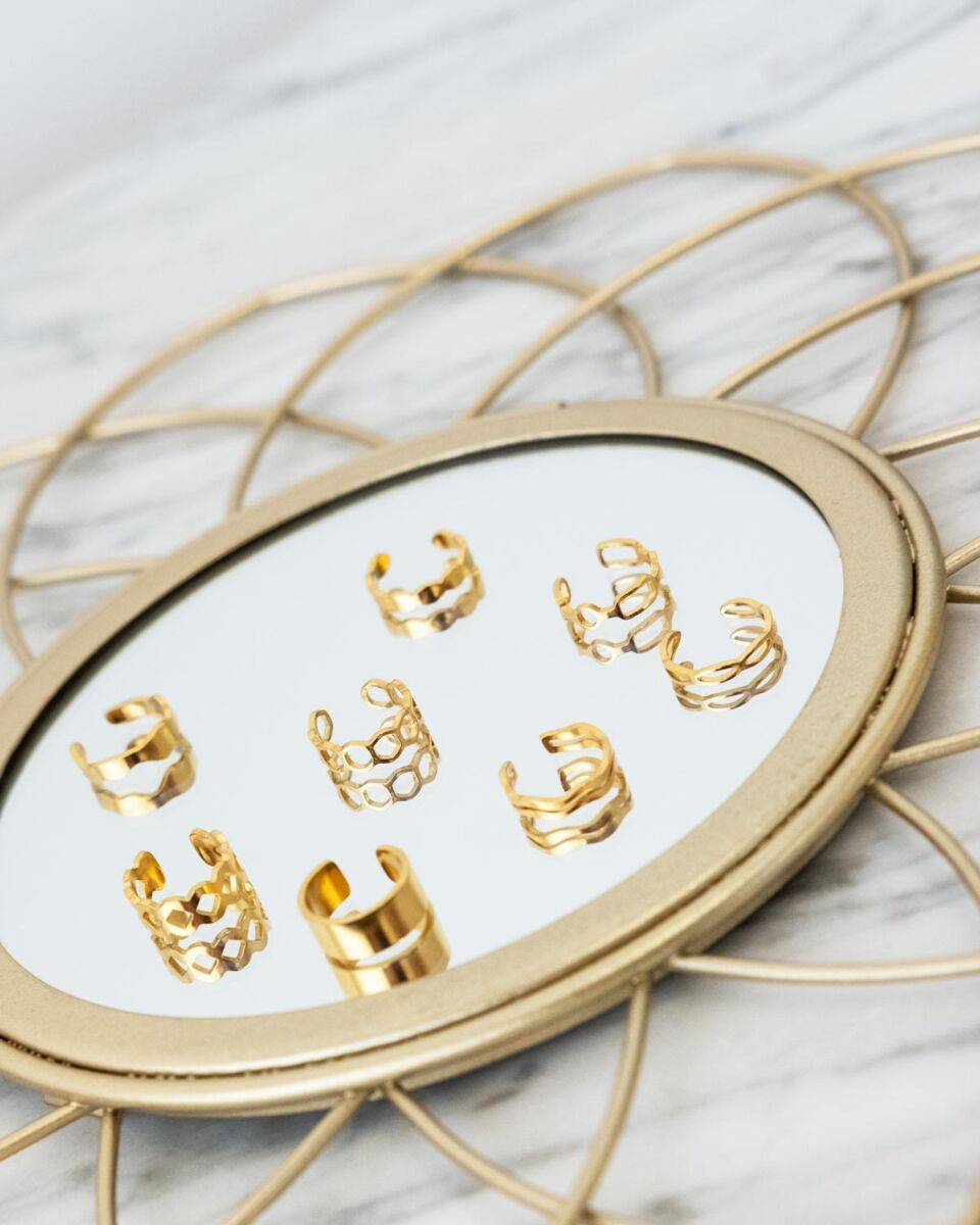 Goud kleurige ear cuffs op een spiegel