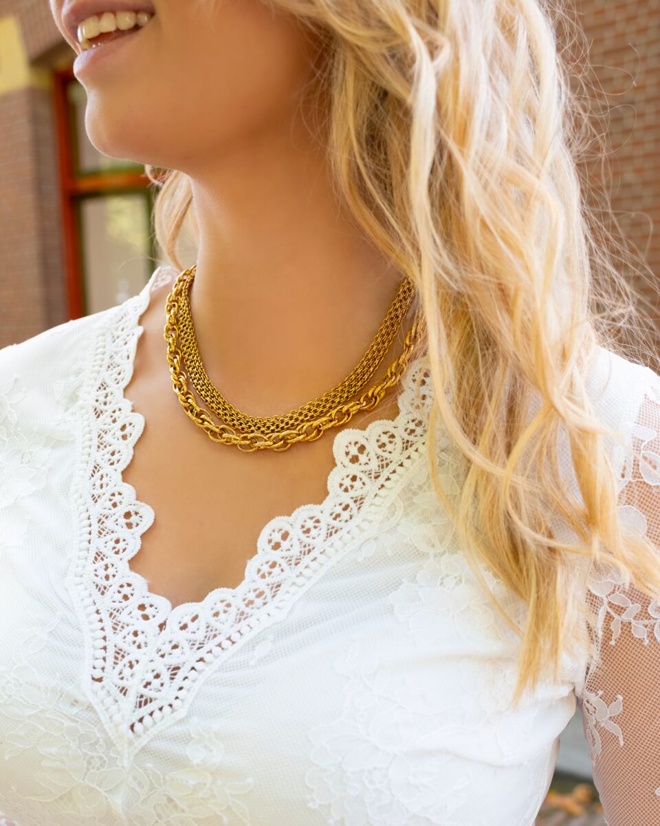 Model draagt gouden mesh ketting