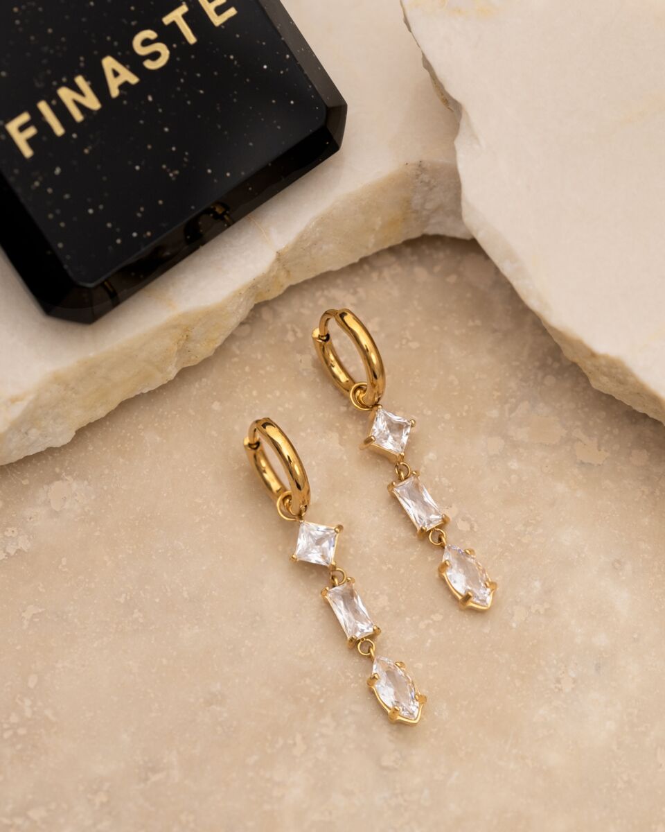 Model draagt gouden sieraden met steentjes