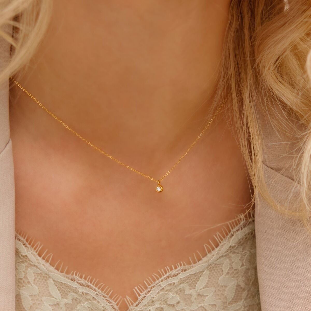 Model draagt gouden ketting met steentje
