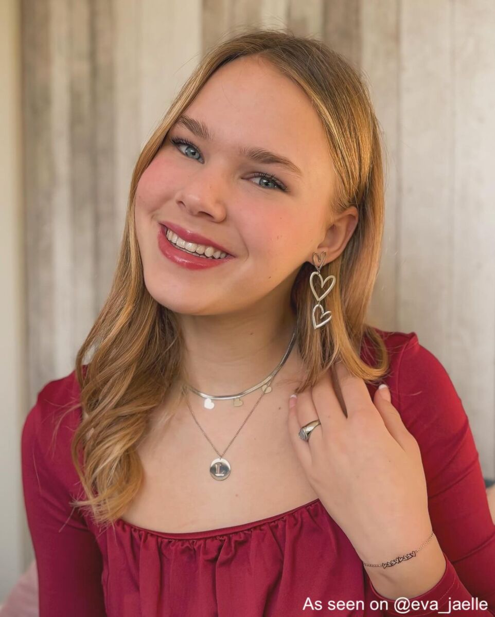 Influencer draagt zilvere ketting met letter
