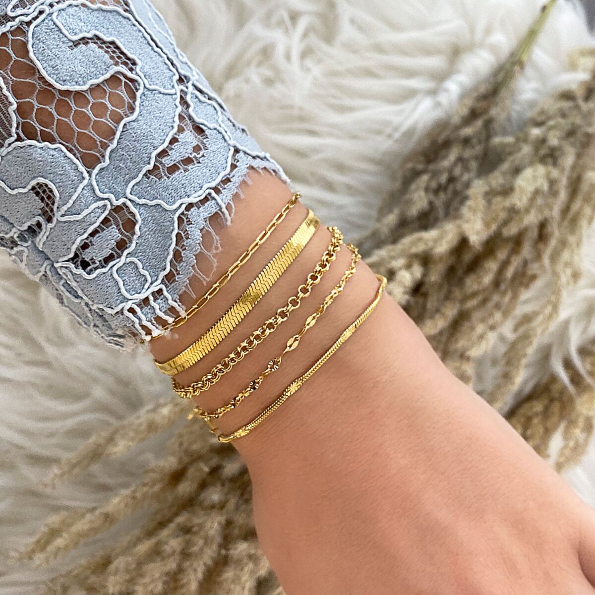 Gouden armbandjes mix om pols bij vrouw