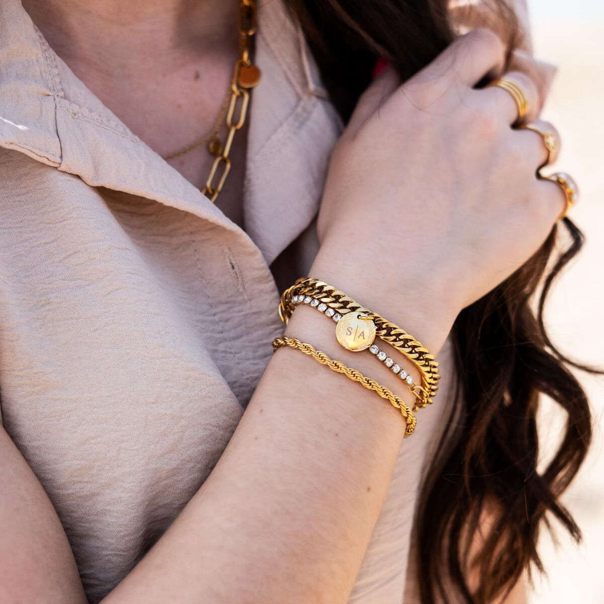 Mooie mix van gouden armbanden om de pols van het model