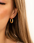 Model draagt gouden hoops