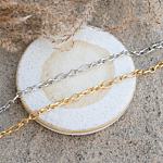 Gouden en zilveren enkelbandjes in het zand