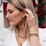 Model draagt gouden oorbellen