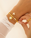 Model draagt gouden clover armbaden mix