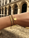 Model draagt mix van gouden armbanden