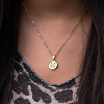 Gouden ketting met letters om de hals bij leopard top