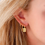 Trendy oorbellen met hanger in het oor bij blonde vrouw