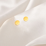 Oorknopje round goudkleurig op wit satijn