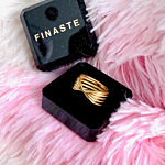 Gouden twist ring in sieradendoosje op roze ondergrond