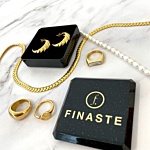 Verschillende goudkleurige sieraden op een marmeren achtergrond