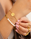 Model draagt gouden armparty om pols