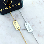 Twee armbandjes met drie initialen op marmer