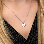 Vrouw draagt zilveren initialen ketting om bij