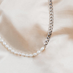 Trendy parel en chain ketting op een satijnen shoppen