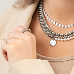 Blonde vrouw met zilveren kettingen met parels en gravering