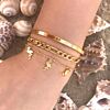 Gouden armparty op het strand met mix van armbandjes