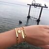 Mooie gouden armparty om de pols voor een stoere look op het strand