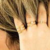 Minimalistische gouden ringen bij vrouw met blond haar