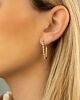 Vrouw draagt tennis earrings met kettinkje