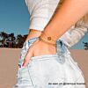 Gouden armparty bij influencer op strand