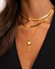 Model draagt necklace layer met mooie gouden kettingen