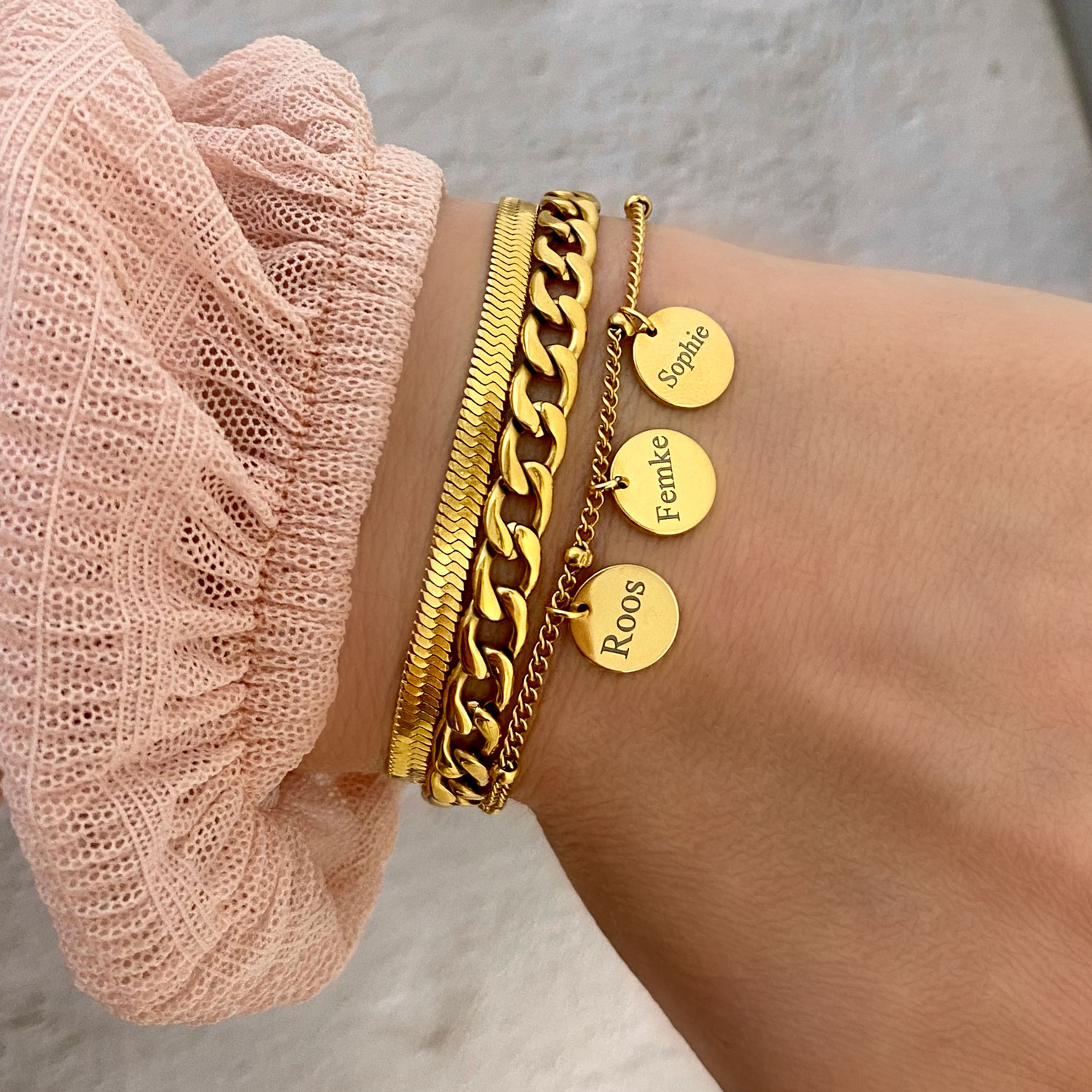 gouden armparty met gravering om pols