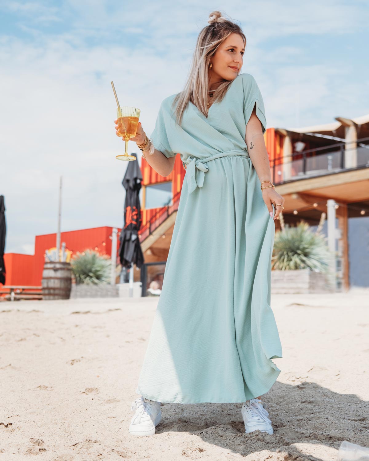 vrouw op strand draagt blauwe maxi jurk