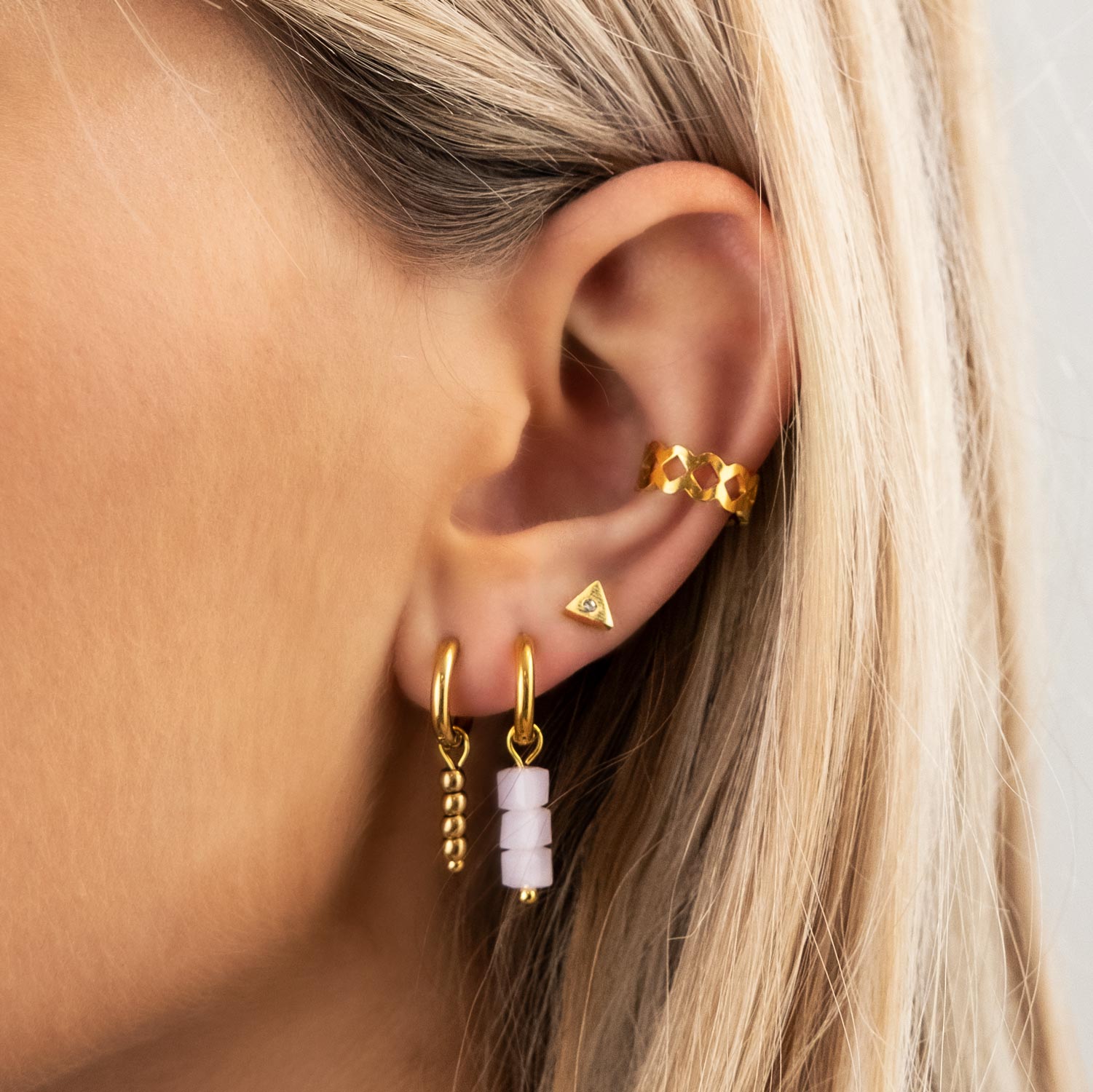 gouden ear cuff en oorbellen in oor